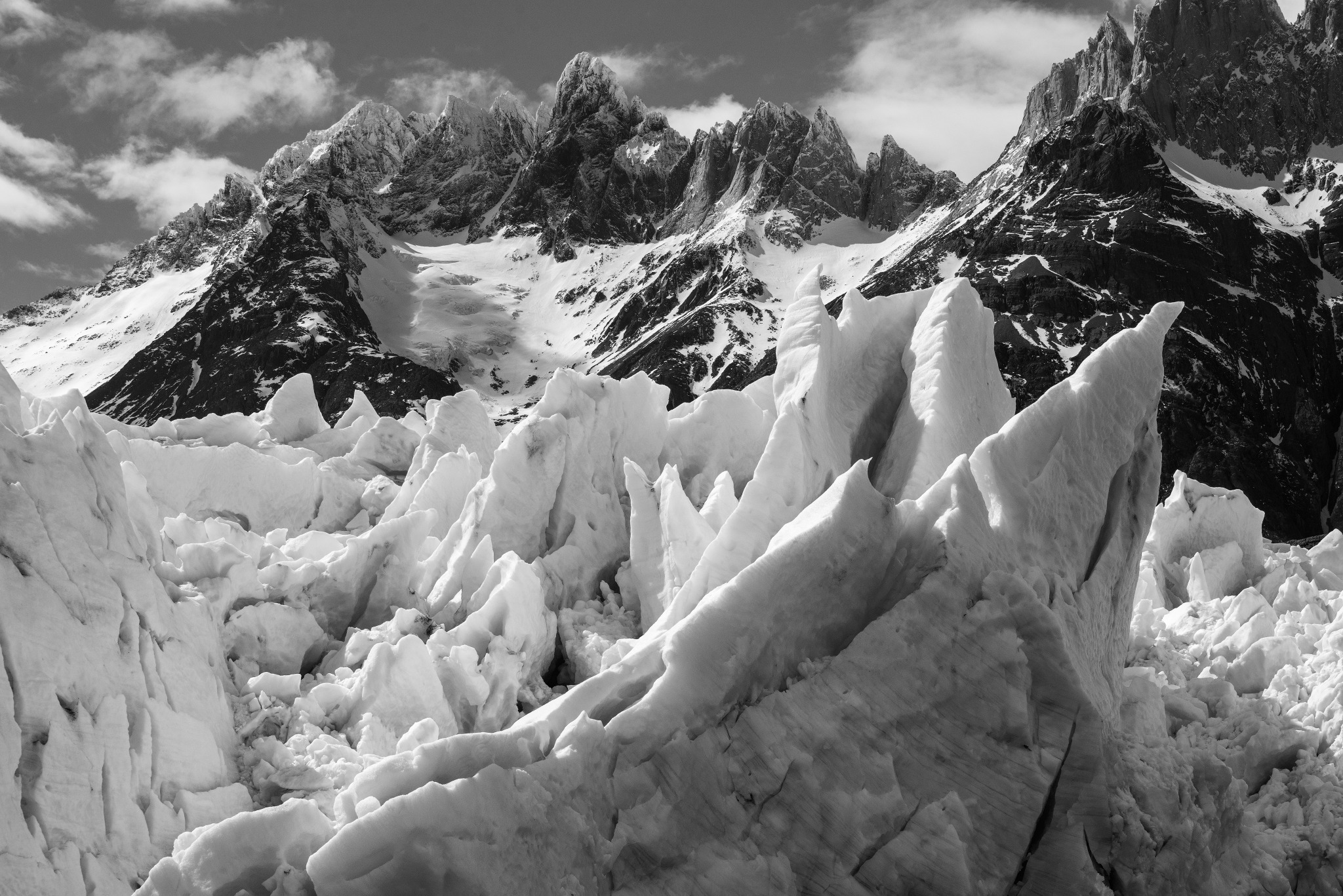 Fractured ice before the Torres del Paine mountains in black and white